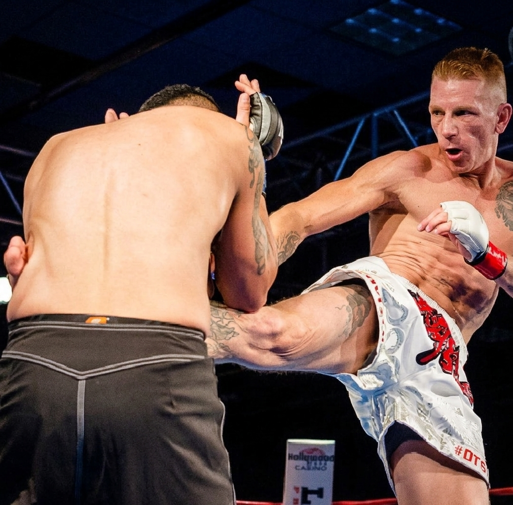 Travis Garlits landing a kick in a Muay Thai bout